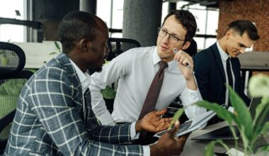 man speaking to coworker and looking skeptical