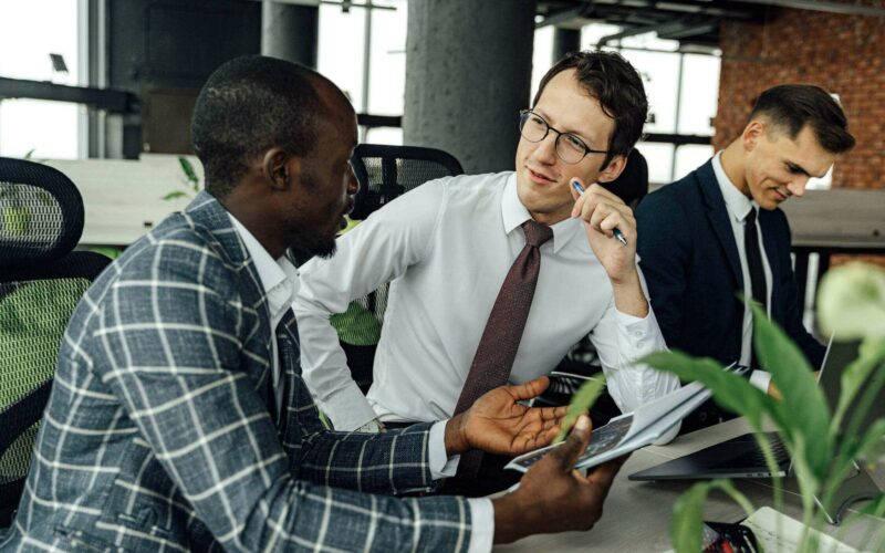 man speaking to coworker and looking skeptical