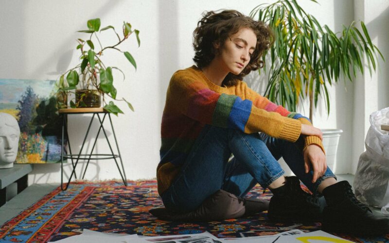 woman sitting on carpet looking to the side