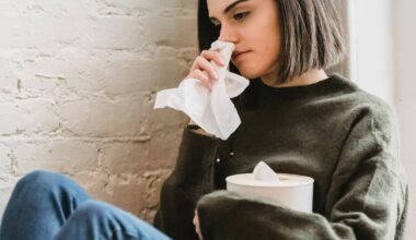 woman with tissue blowing her nose