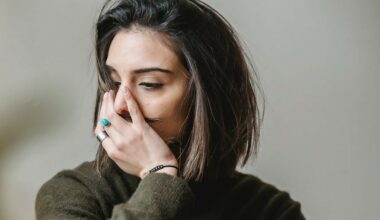 woman deep in thought looking to the left with a hand over her mouth