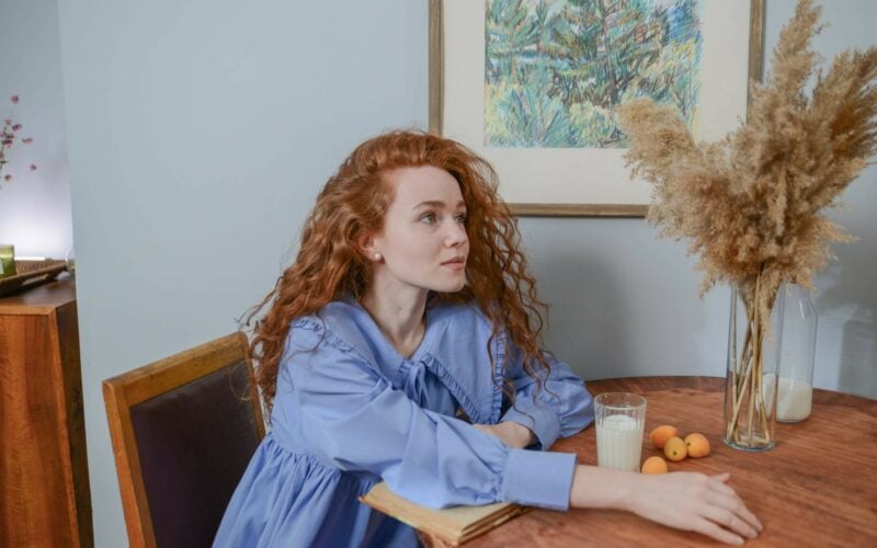 woman with red hair sitting at table