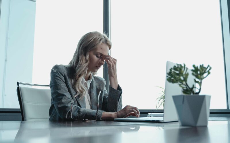 woman sitting at desk looking stressed