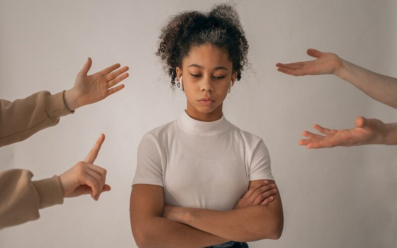 Faceless people scolding discontent black girl