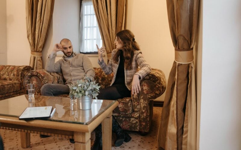 couple sitting on couch and arguing