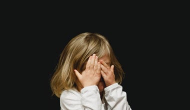 young girl covering her eyes