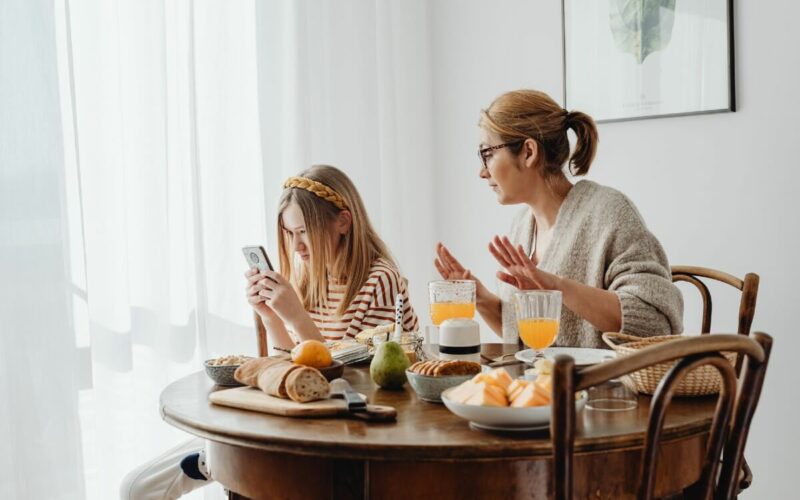 mother speaking to daughter while she looks on her phone