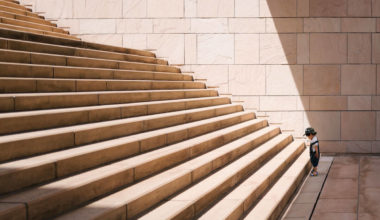 young boy staring up a large staircase