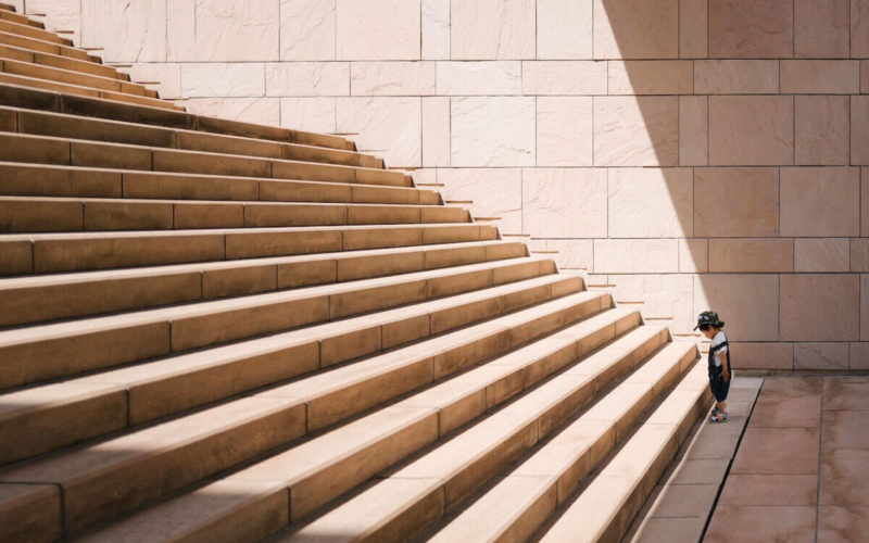 young boy staring up a large staircase