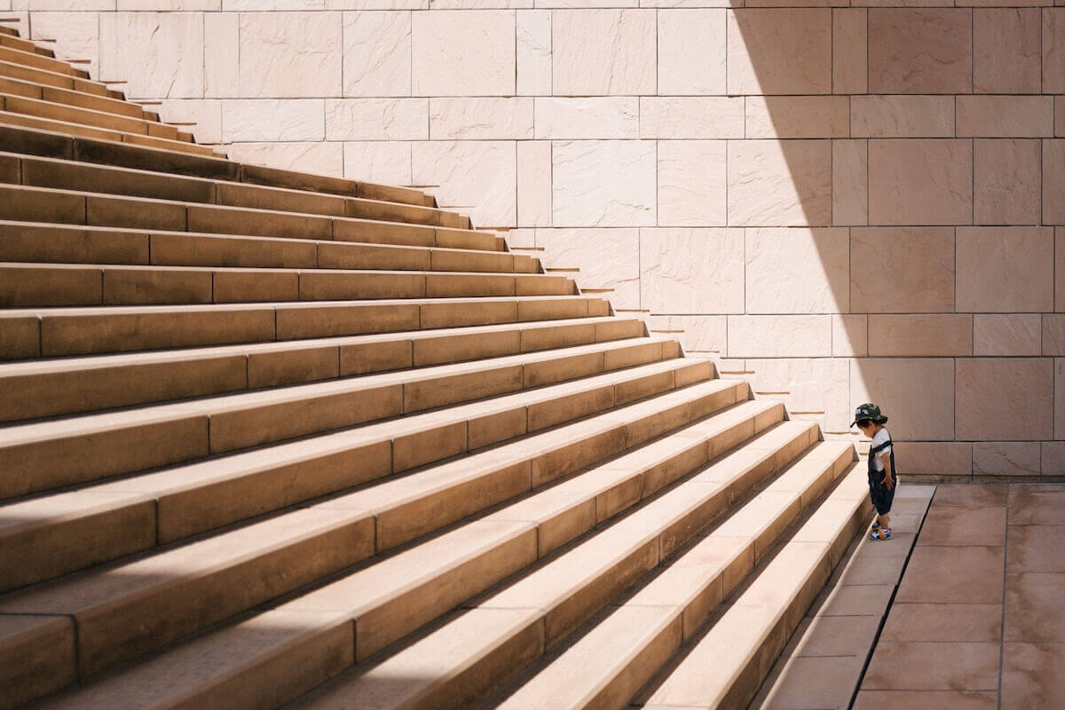 young boy staring up a large staircase