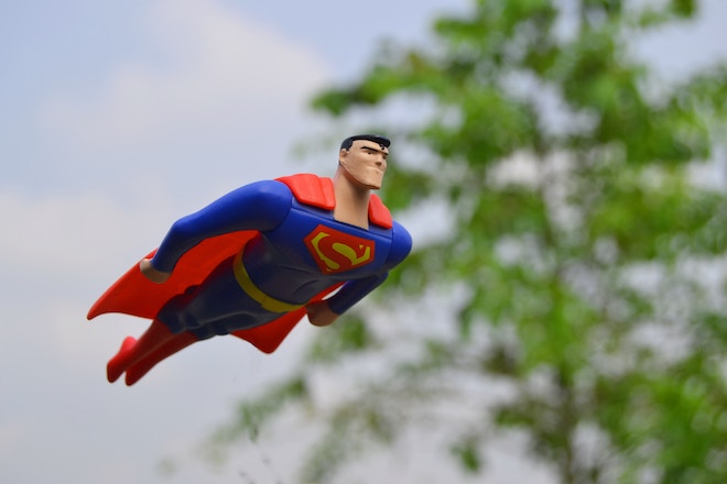 A superhero glides through the air on his way to save someone