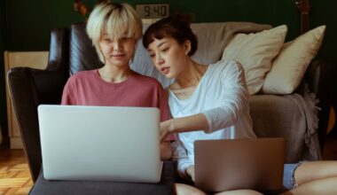 two people sitting side by side looking at laptops