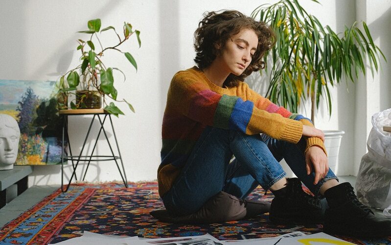 Traumatized young woman sitting on the floor