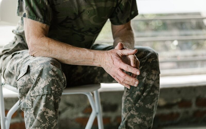 Veteran sitting on a bench in camouflage uniform