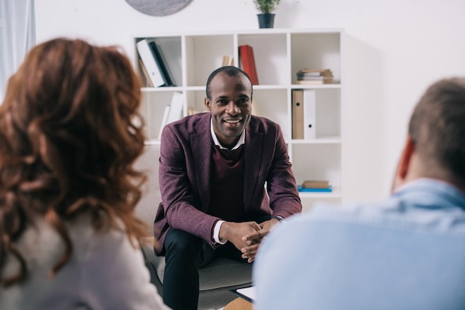 A male counselor talks to a couple