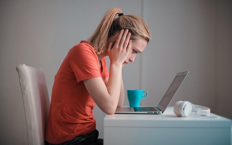 Young troubled woman using laptop at home