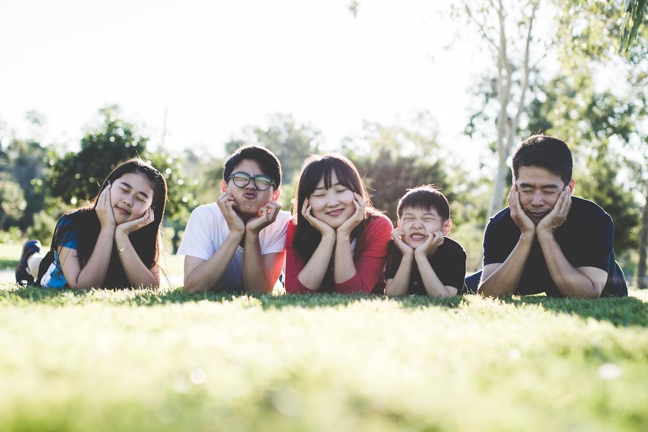 Family on the grass making funny faces