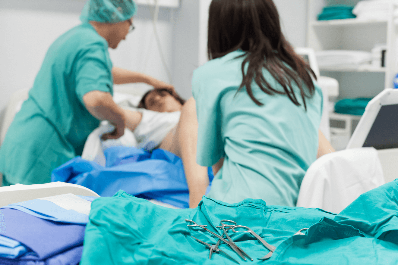 woman giving birth doctor and nurse treating her