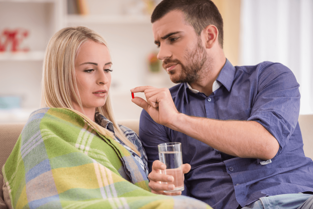 couple man giving sick woman pill glass of water