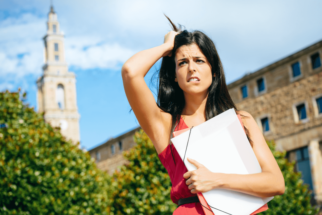 female college student stressed grabbing hair holding binder