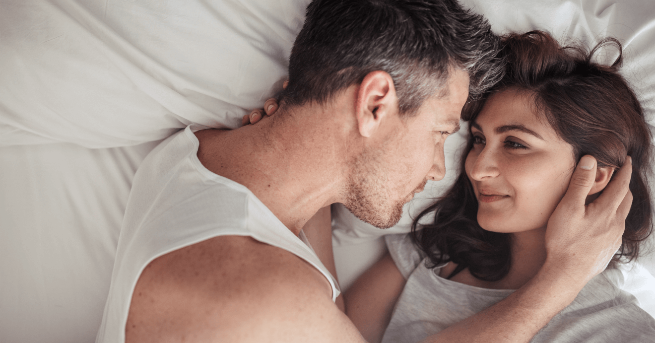 couple in bed holding each other tenderly