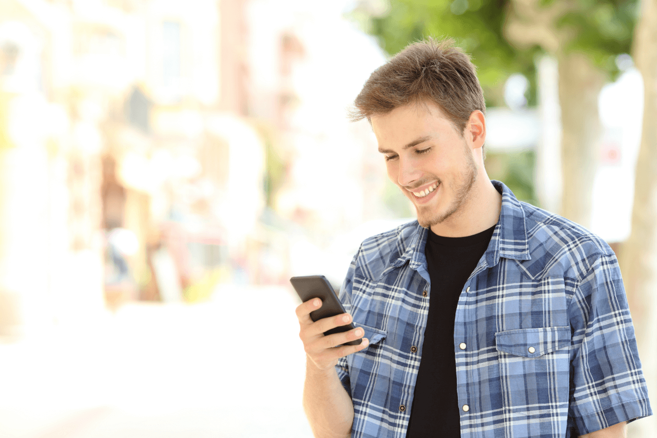 man smiling holding phone