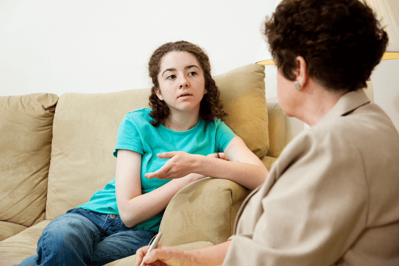 female college student on couch with therapist