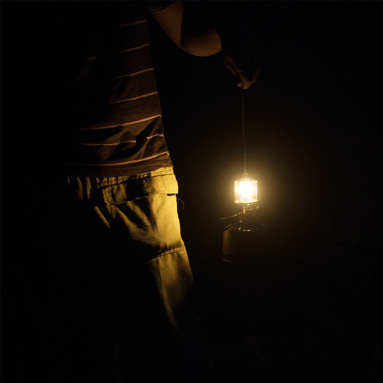 man holding gaslight dark background