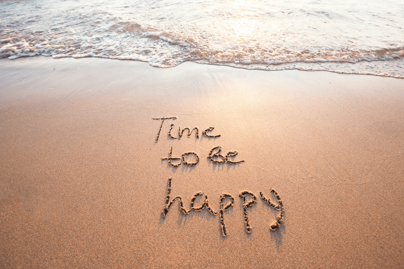 time to be happy written in beach sand wave behind