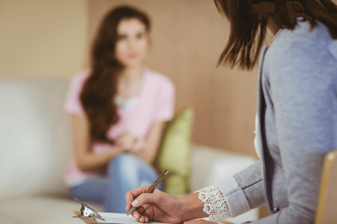 therapist taking notes female client on couch