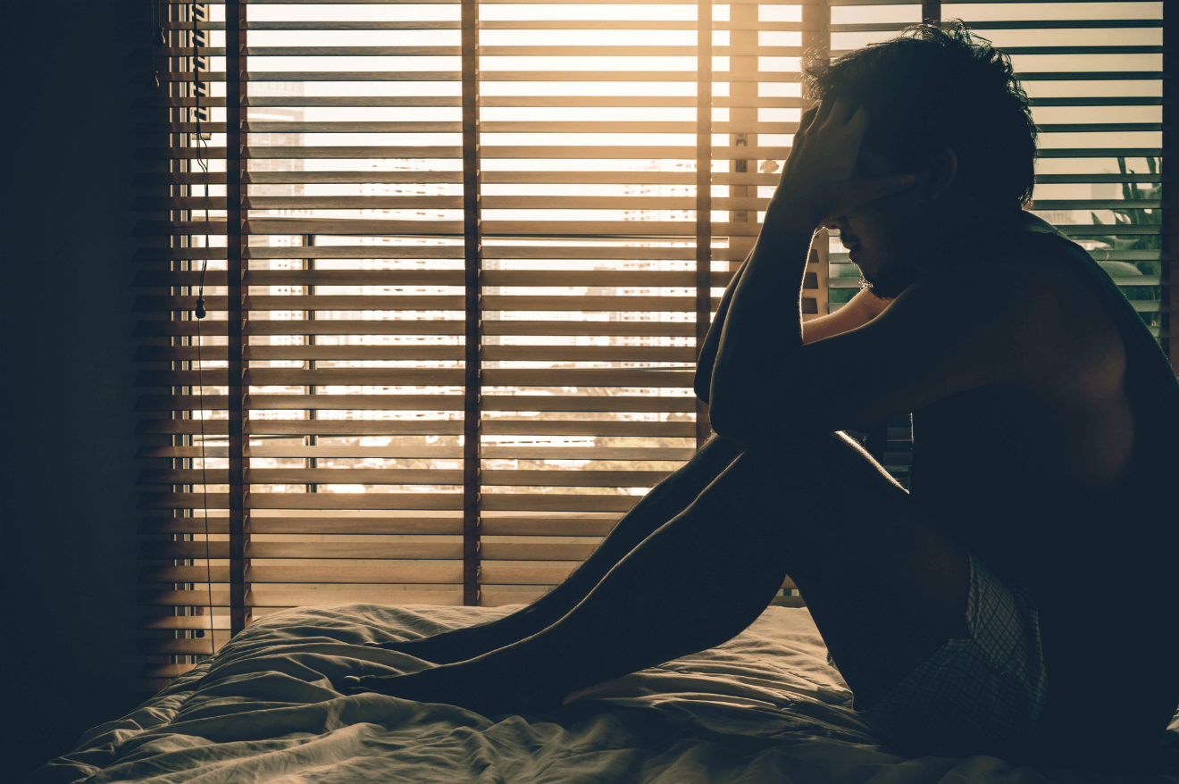 depressed man sitting in bed