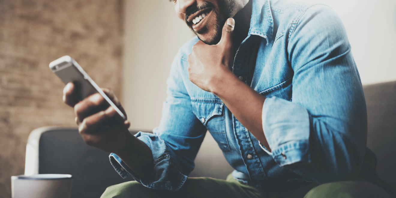 man holding smartphone on couch