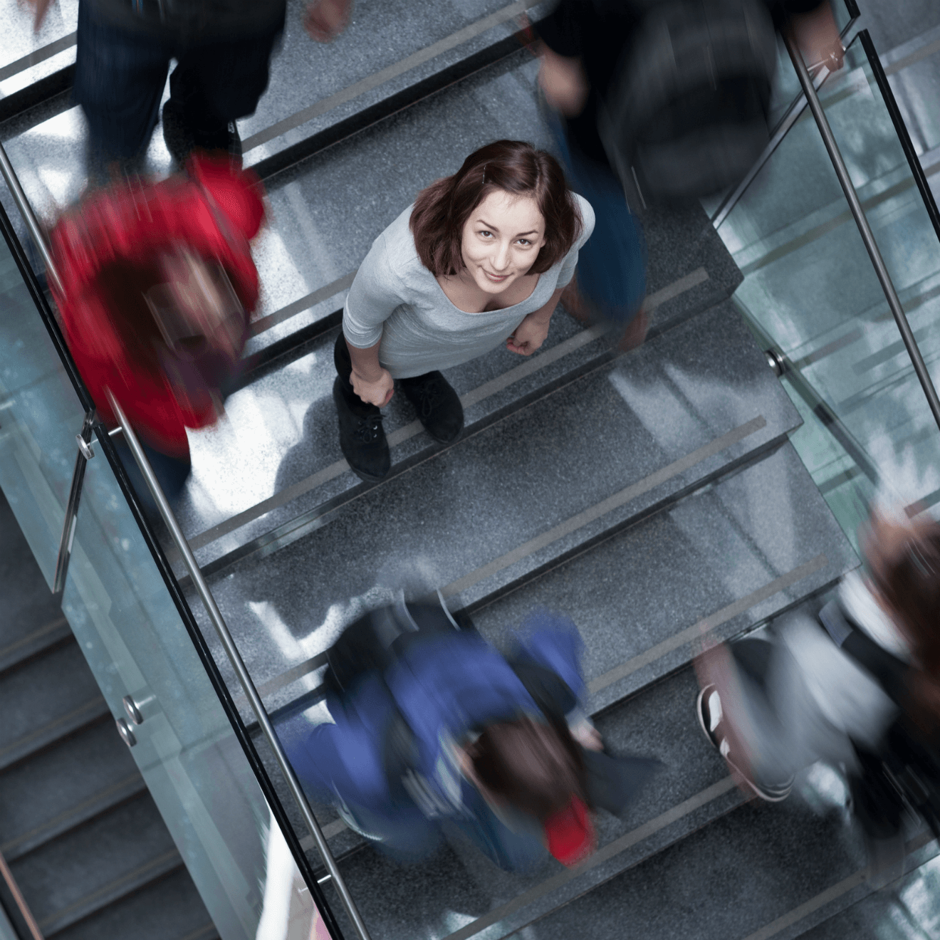 woman standing on stairs in crowd looking up at camera