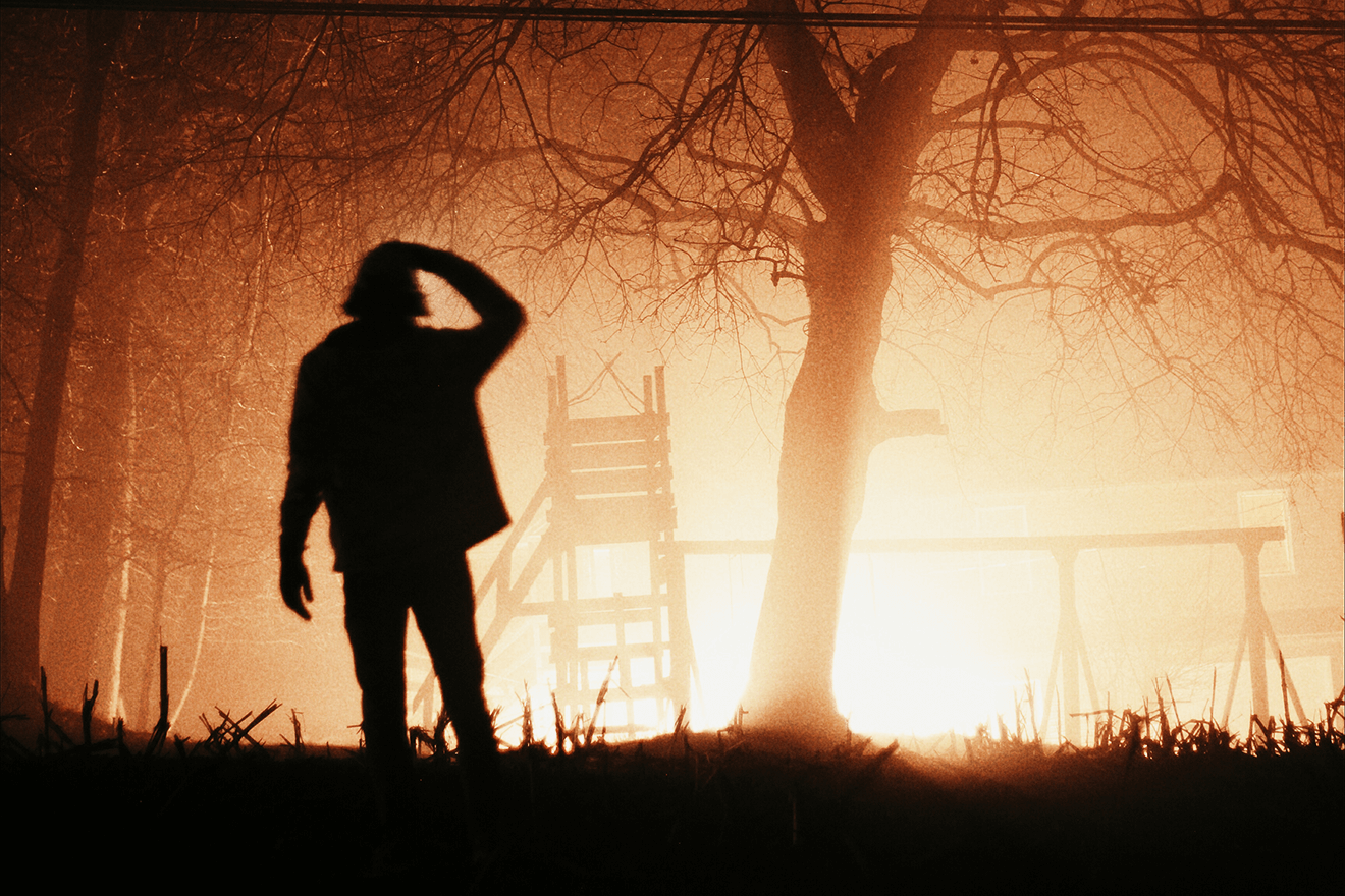 Man silhouetted in front of fire