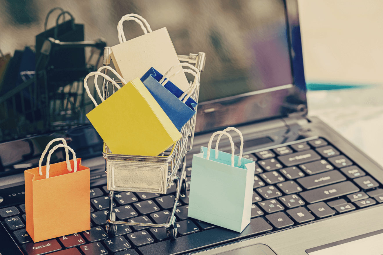 miniature shopping bags and cart on computer