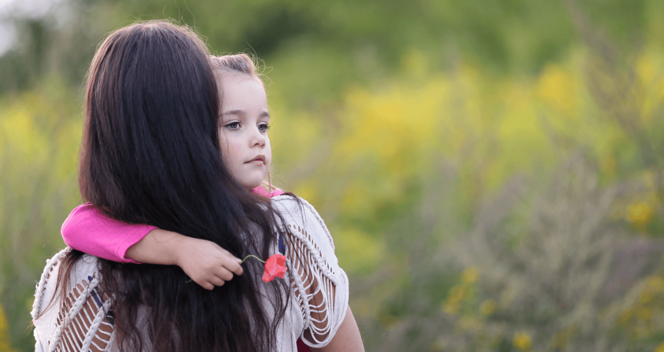 single mom holding daughter field