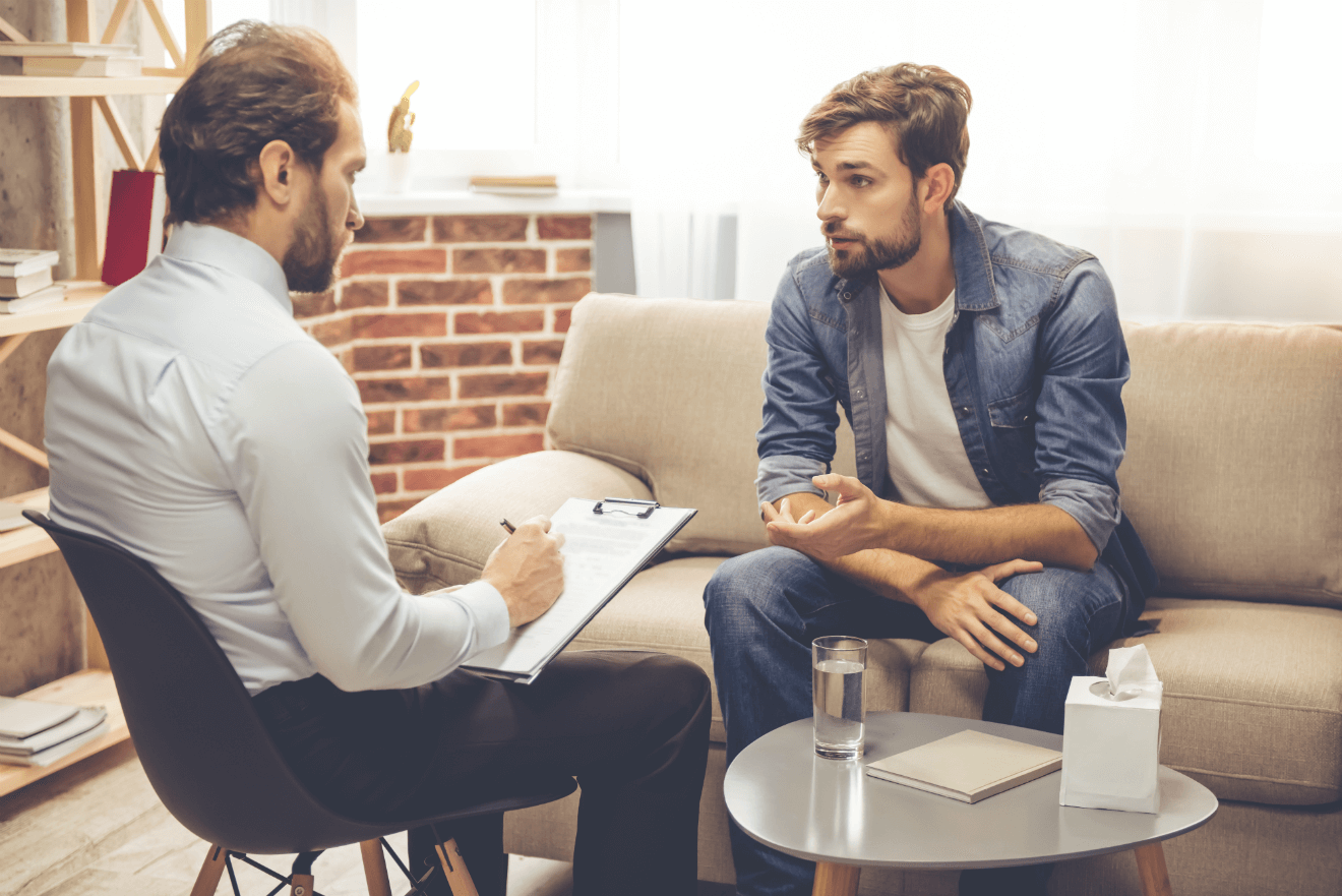 therapist with notepad and client on couch