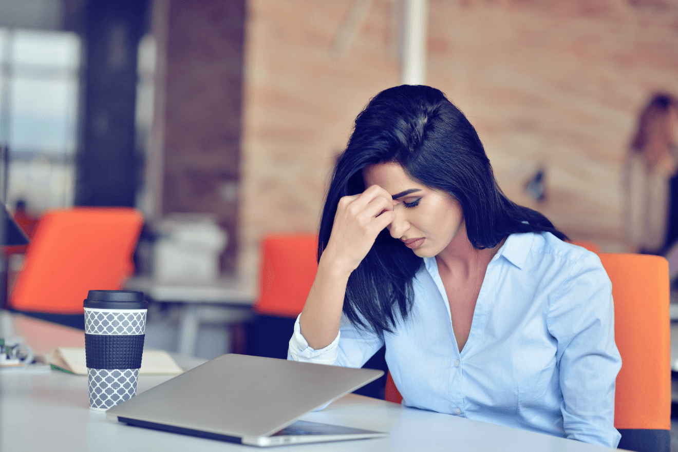 stressed woman at work with coffee and laptop