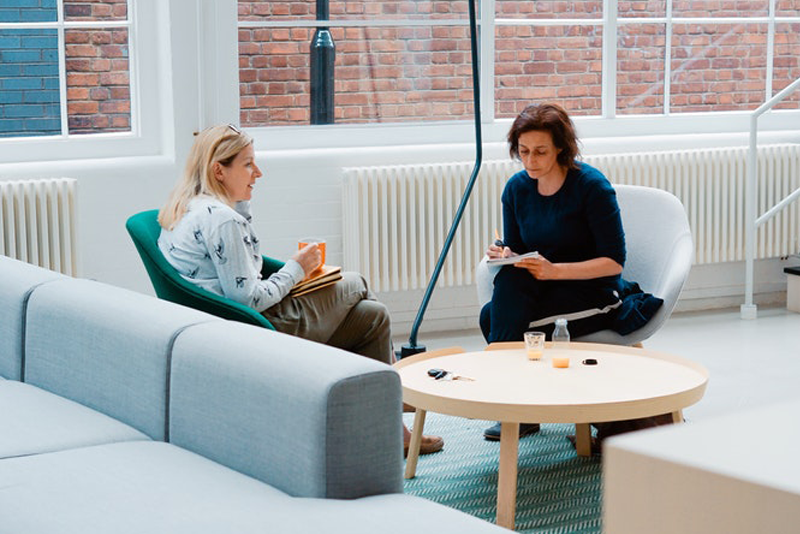 Two women sitting close and discussing things