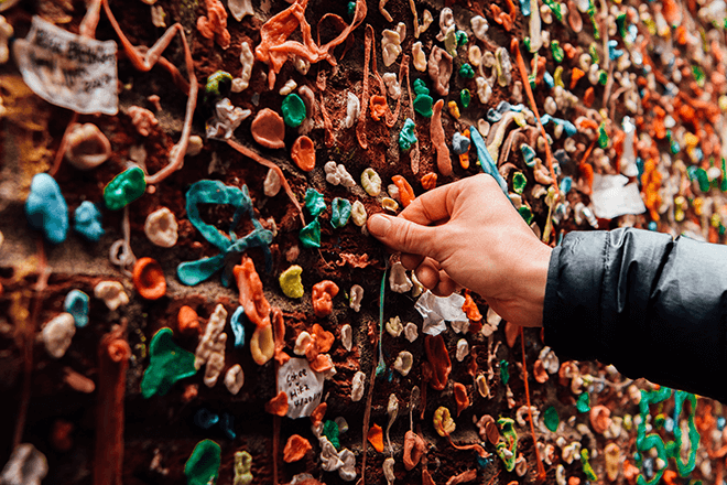 A man touching a wall of gum