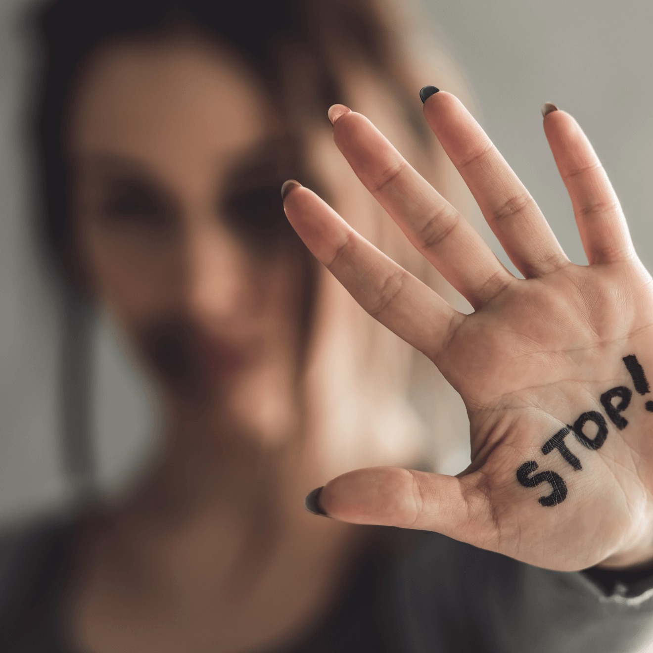 sexual violence survivor with stop written on hand