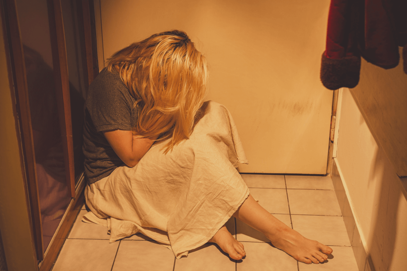 woman on floor next to shower white towel